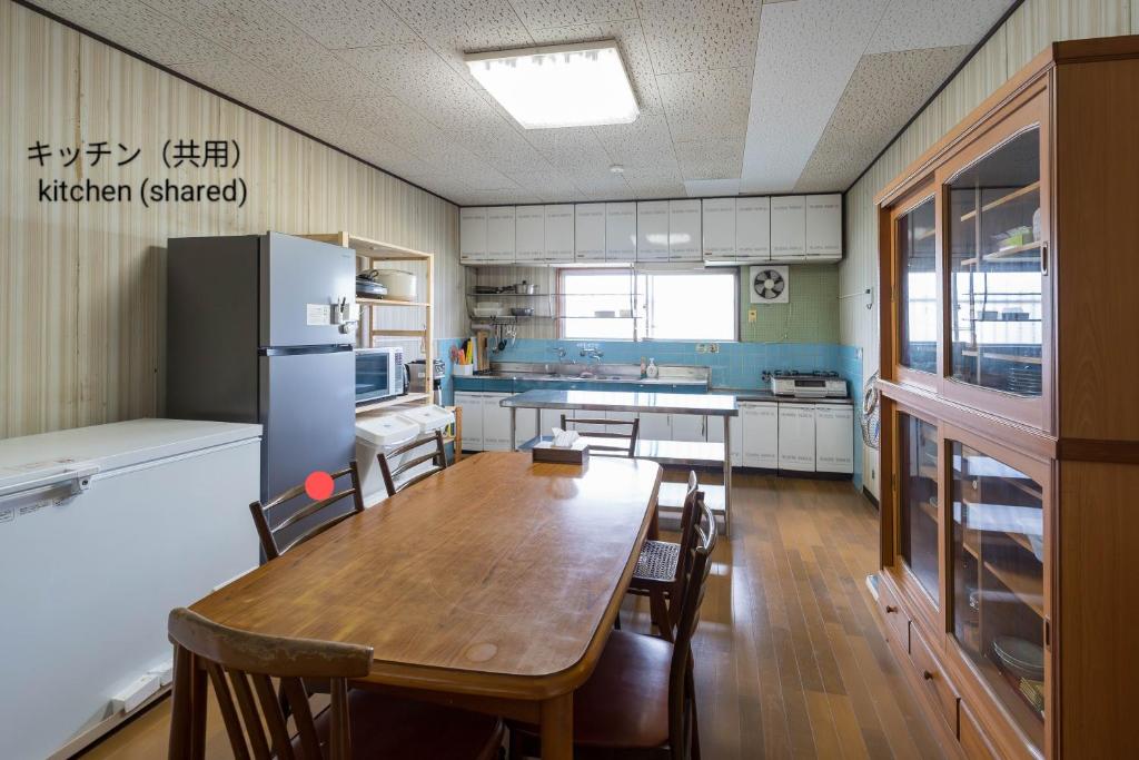 Zentsuji深山邸miyama-tei的厨房配有木桌和冰箱。