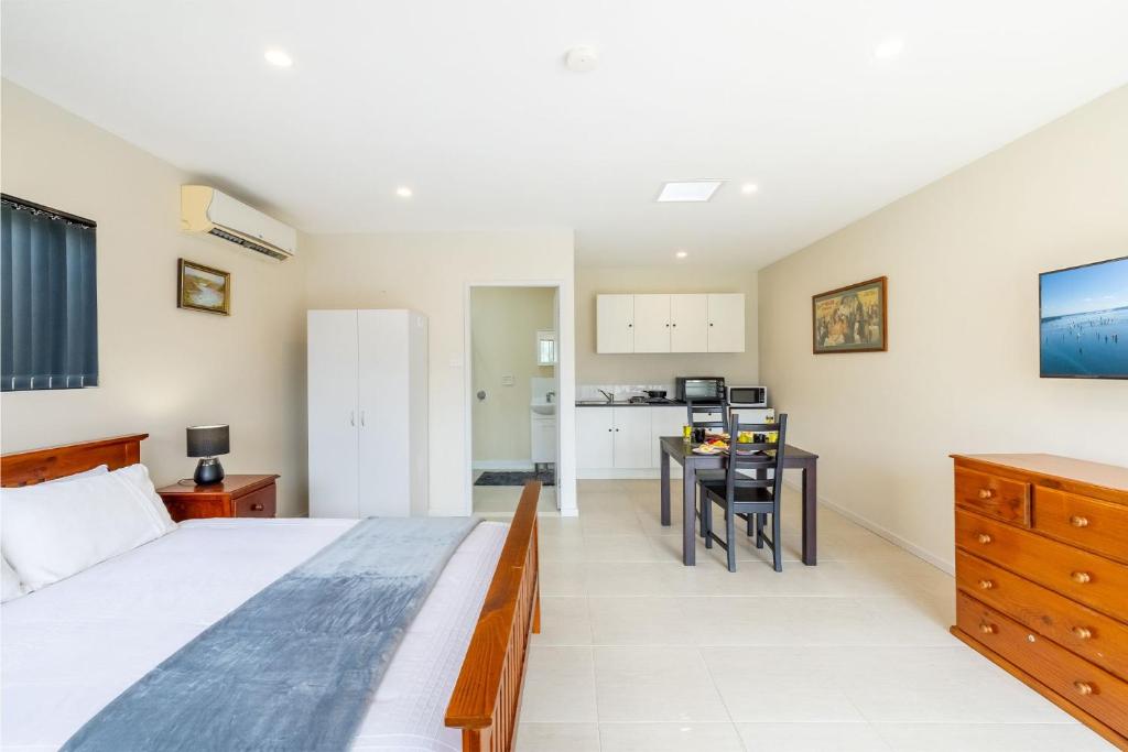 尼尔森湾14A Grafton St - Pet friendly studio with air con and wi-fi的一间卧室配有一张大床和一张桌子