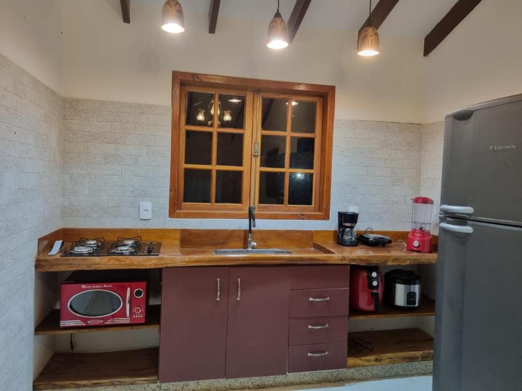 皮雷诺波利斯Sítio Quinta da Mata Chalé Amarelo的厨房配有带水槽的柜台和冰箱。