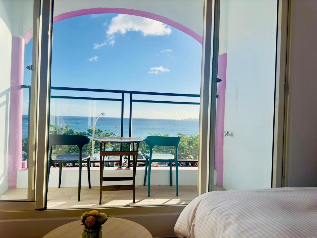 南湾南灣陽光皮小妞 Pii hostel的卧室设有大窗户、桌子和椅子