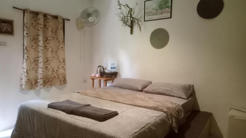 Phra Ae beachnavaa Bungalow的卧室里的一张床铺,床上有毯子
