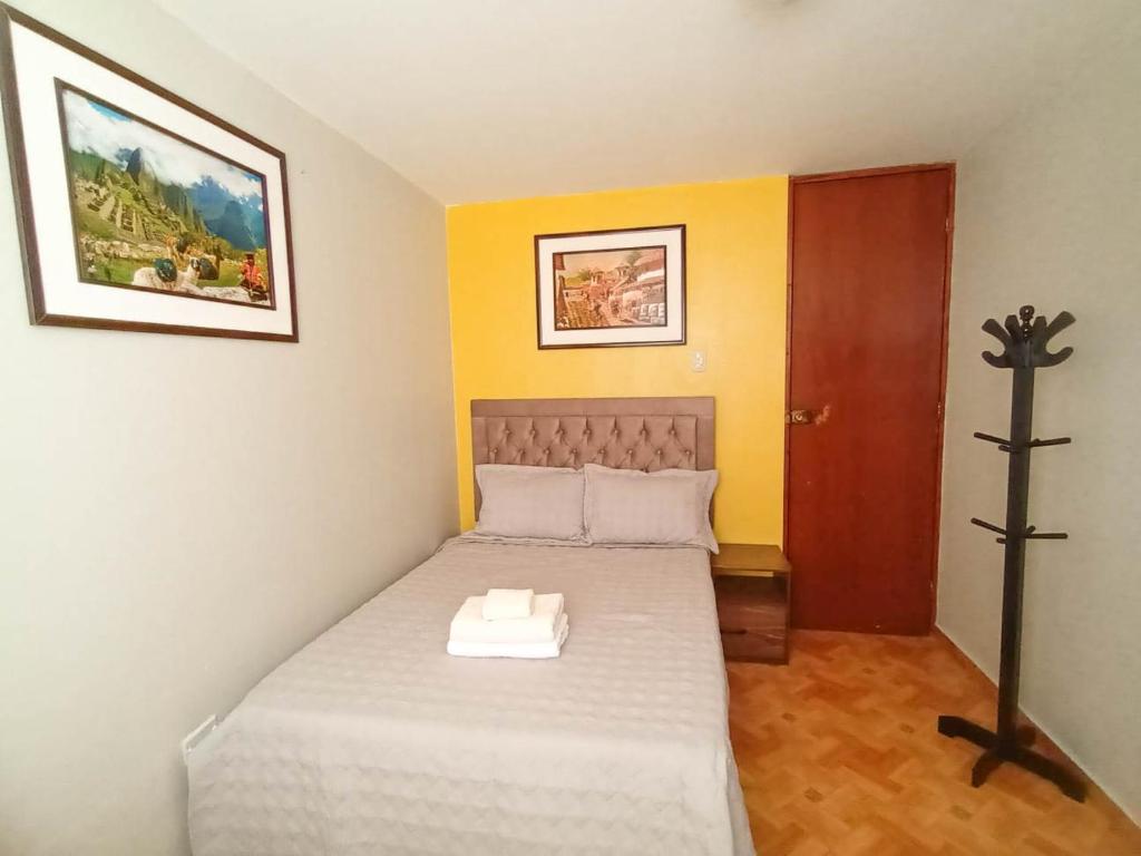 利马Confortable habitación doble frente al Aeropuerto的小卧室配有一张带横跨床的床铺