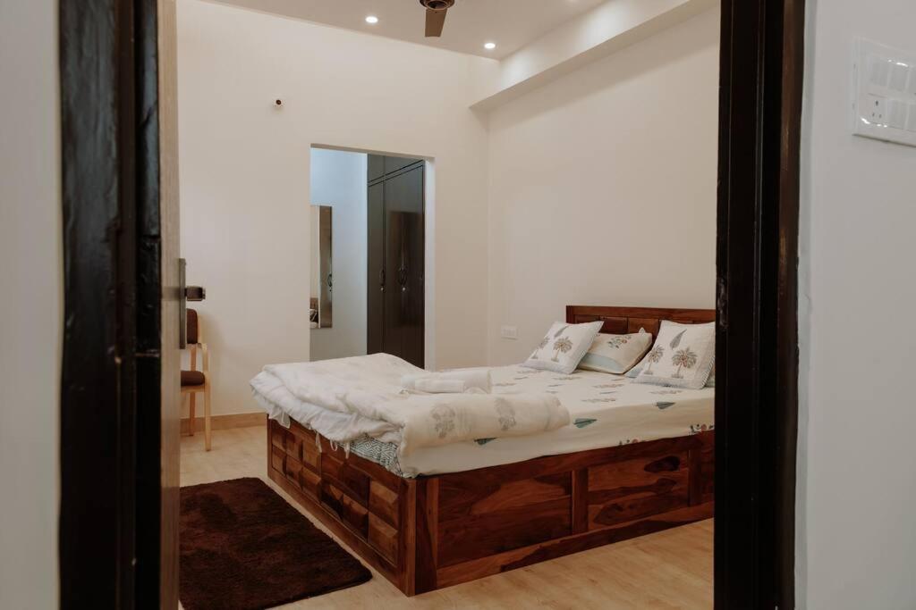 斋浦尔Casa Paradis- secure, cozy& peaceful paradise in heart of most happening colony的一间卧室配有一张带镜子的木床