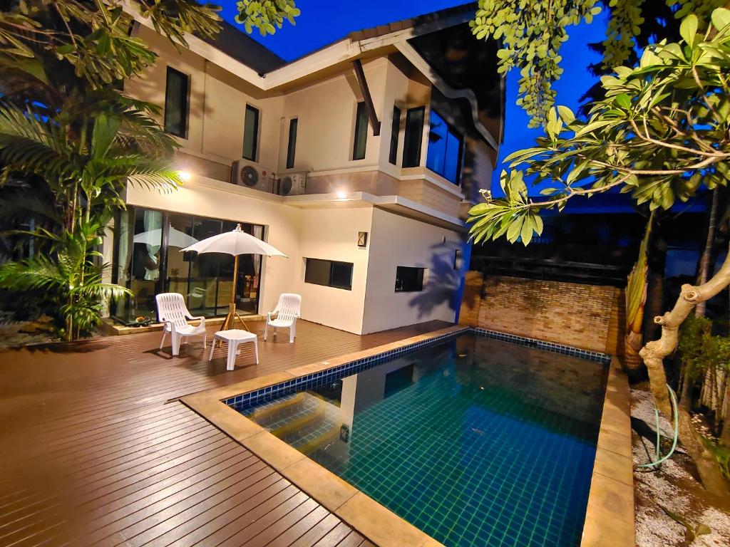 芭堤雅市中心Baan Natcha Villa的夜间带游泳池的别墅
