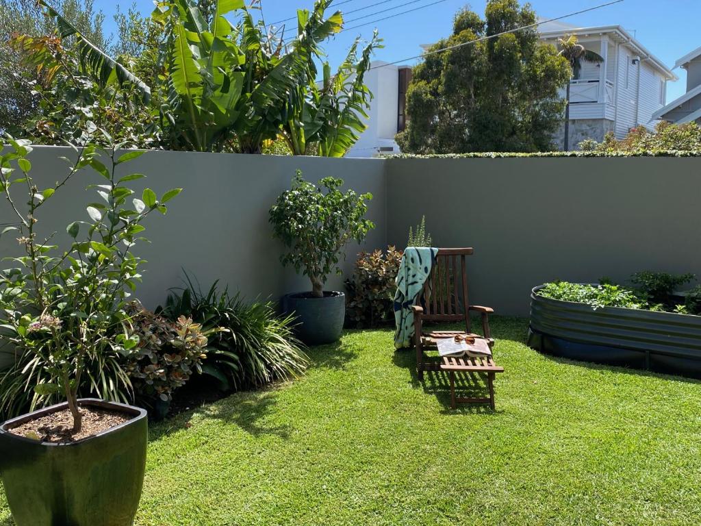 悉尼Seaside Escape的一个带长凳和一些植物的花园