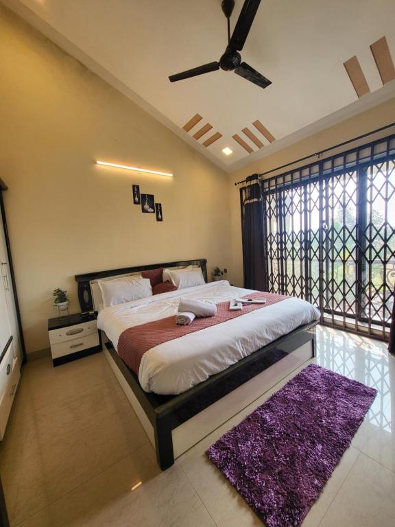 罗纳瓦拉THE PERFECT STAYS: CHOUDHARY VILLA的一间卧室配有一张大床和吊扇