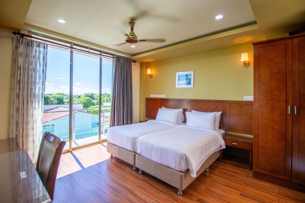 科卢马杜卢Blue Wave Hotel Maldives for SURF, FISHING and Beach的一间卧室设有一张床和一个大窗户