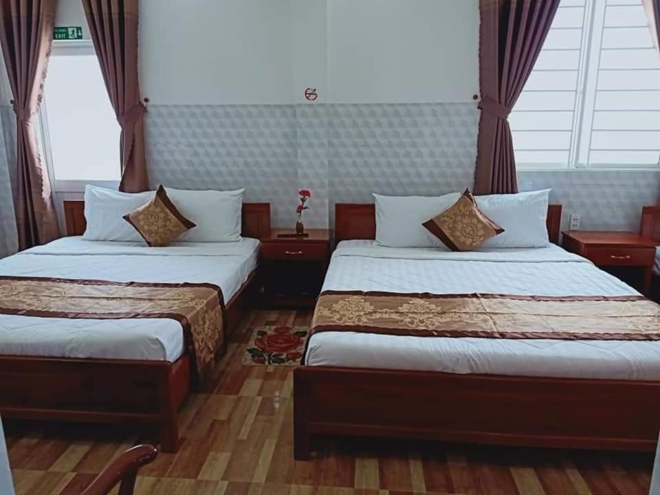 Ấp Trà KhaSơn Tùng Motel的酒店客房设有两张床和窗户。