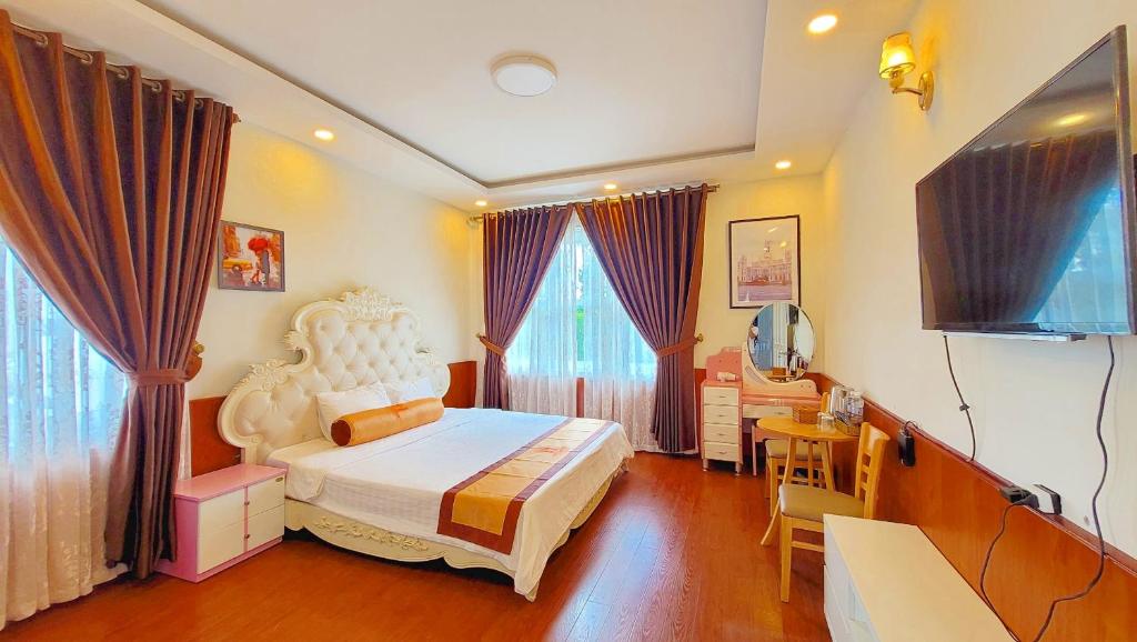 大叻Villa H Flower Đà Lạt的一间卧室配有一张床和一台电视