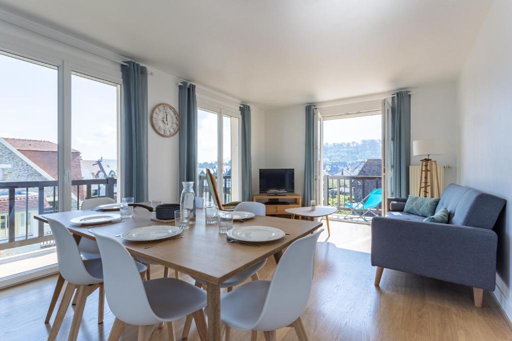 多维尔Le Carrousel - Appartement avec studio attenant的一间带桌椅和沙发的用餐室