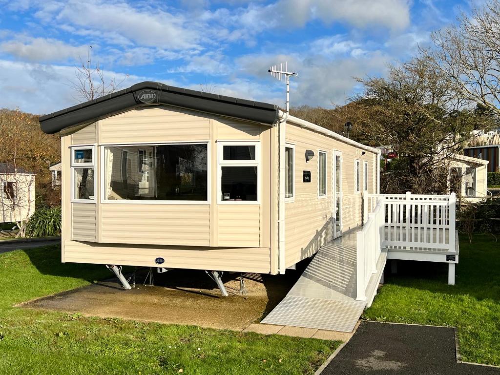 本布里奇2 Bedroom Caravan CW111, Whitecliff Bay, Bembridge, Isle of Wight的黑色屋顶的白色房子