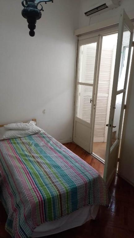 蒙得维的亚Cordón的一间卧室设有一张床和一个滑动玻璃门