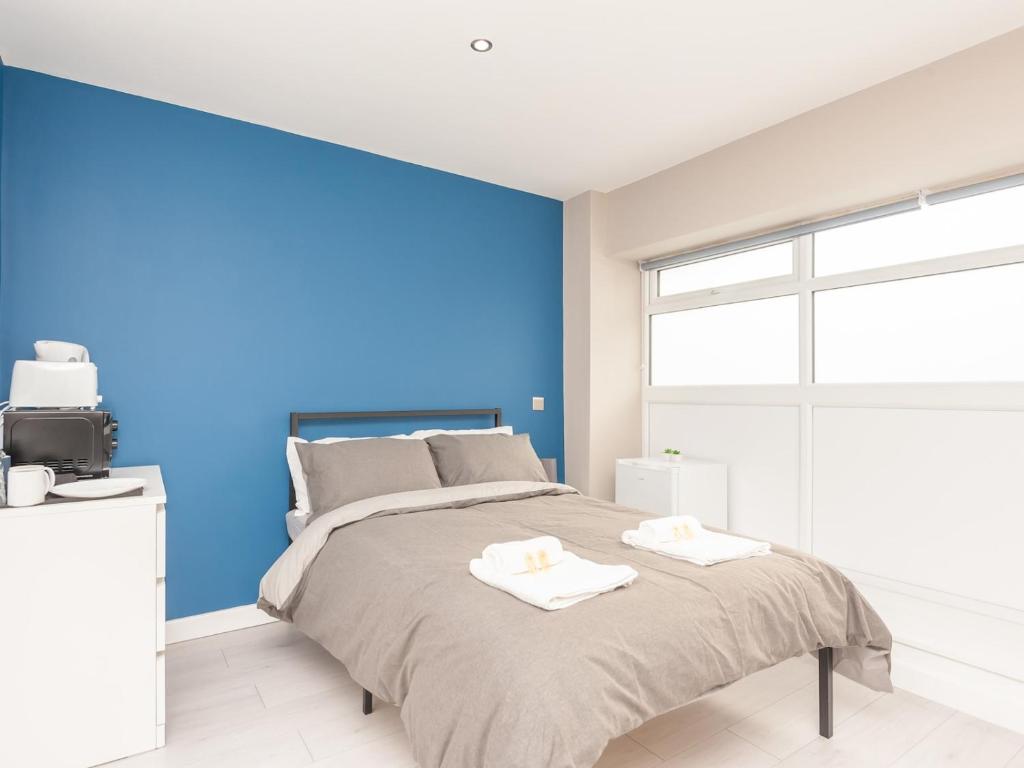 伯恩利Pass the Keys Burnley Central Hub Stylish Stay的一间卧室设有一张蓝色墙壁的大床