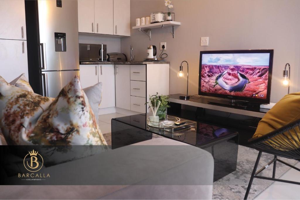 马塞卢Barcalla Hotel Apartments的一间客厅,配有一张桌子上放的电视