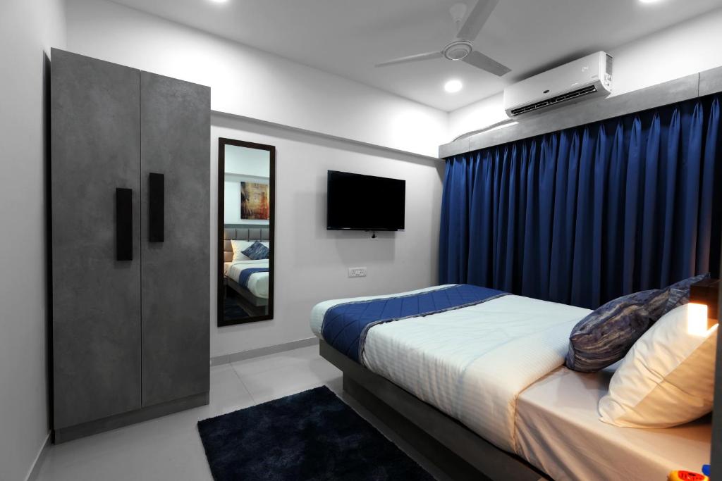 孟买Axon Aleta的一间卧室配有一张床和一台电视。