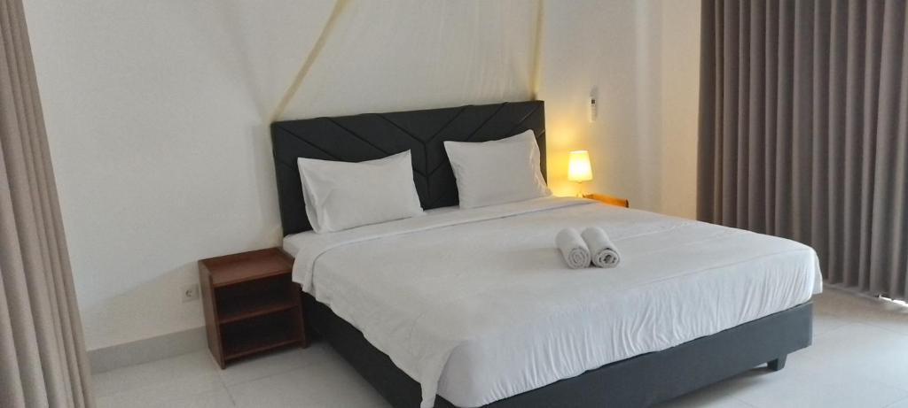 吉利阿尔parida bungalow的一间卧室配有一张大床和两条白色毛巾