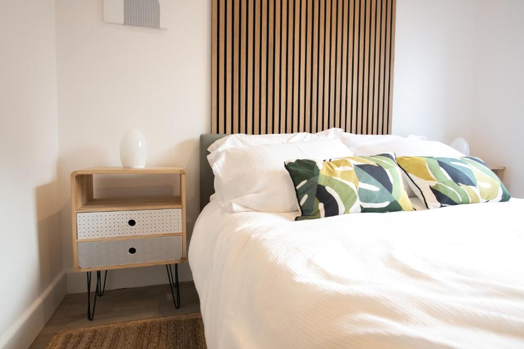 浦耳Dorset Stylish Apartment的一间卧室配有一张床,旁边设有床头柜