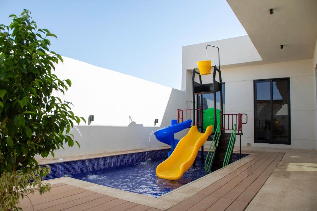 Khalij Salmanالمرفأ 2 شاليه مع مسبح والعاب مائية وغرف نوم فاخرة的一个带滑梯的游乐场的游泳池