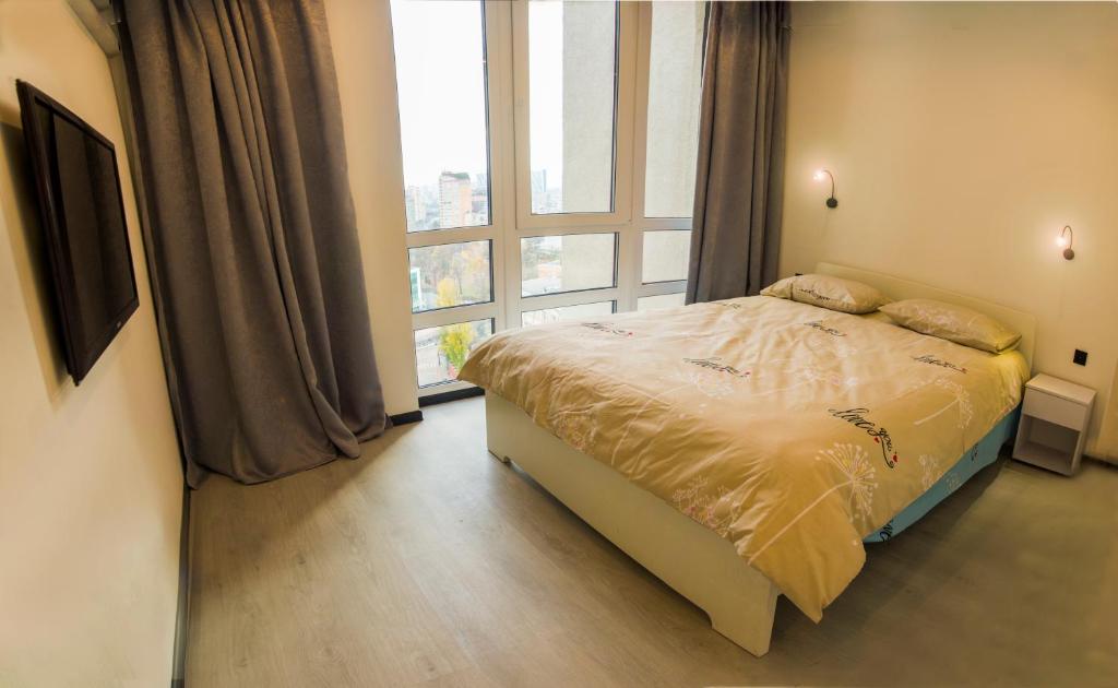 基辅Апартаменты в новострое рядом с центром的一间卧室设有一张床和一个大窗户