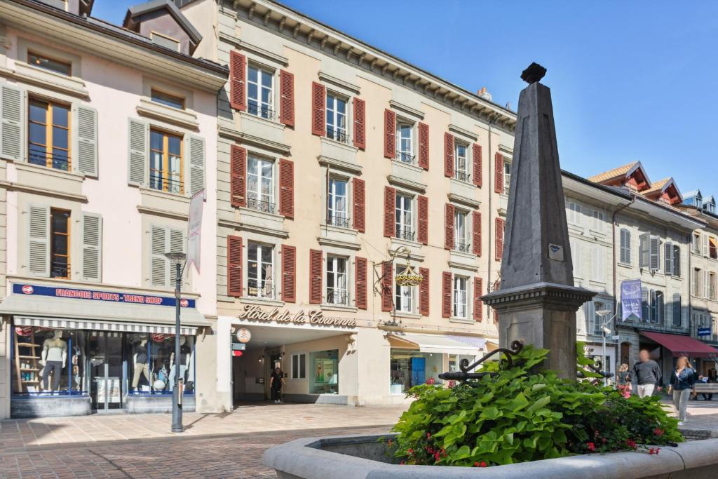莫尔日Hôtel de la Couronne的街道中间的雕像,有建筑