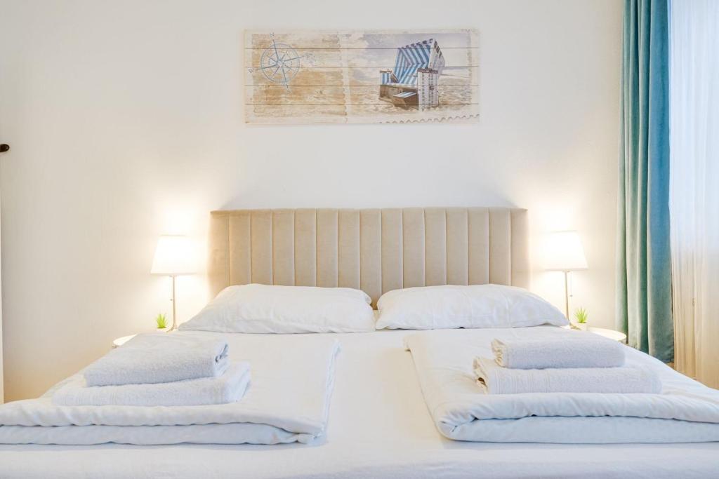 因斯布鲁克Wohnen auf Zeit - Studiowohnung Innsbruck的一间卧室配有两张带白色床单和枕头的床。