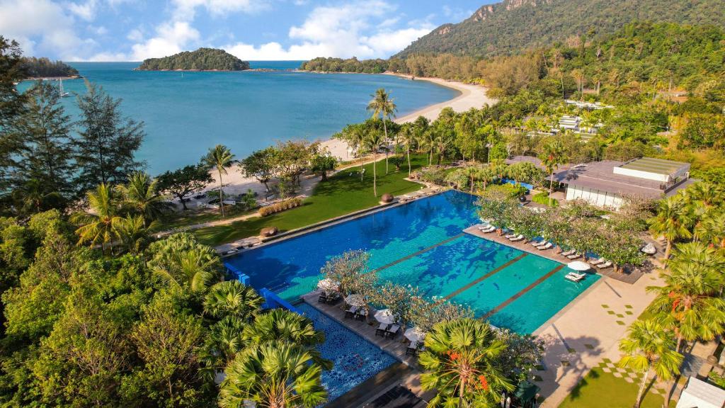 立咯海滩The Danna Langkawi - A Member of Small Luxury Hotels of the World的享有带游泳池和海滩的度假村的空中景致