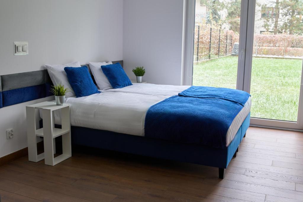 华沙Top Loft Znana的一间卧室配有一张带蓝色枕头的大床