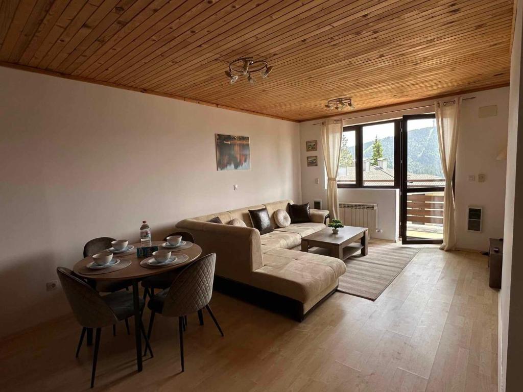 潘波洛沃Pamporovo Rhodopi Pearl Apartments的客厅配有沙发和桌子