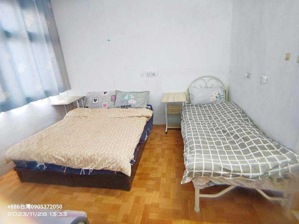 金湖镇金門瑜仙-住宿租機車-接機免費的一间卧室设有两张床,铺有木地板