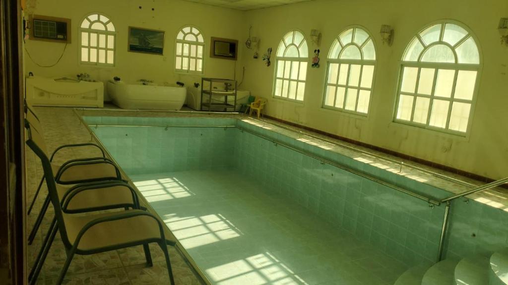 Al RahbaFarm dream的大型浴室设有游泳池,配有椅子
