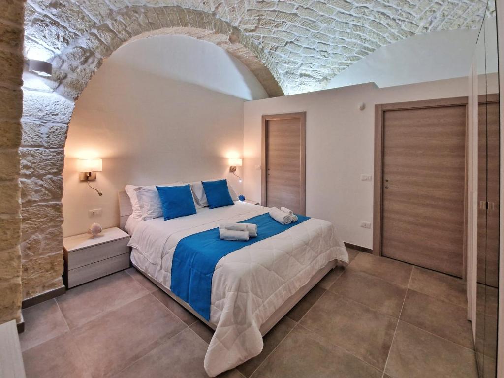 曼弗雷多尼亚Da zia Giovanna Apartment的一间带大床的卧室,位于带拱门的房间