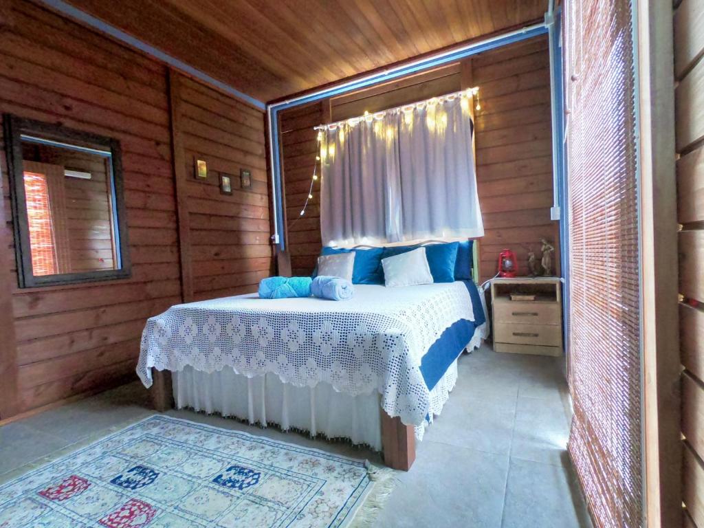 伊比拉奎拉Pousada Bosque das Águas, Imbituba的木制客房内的一间卧室,配有一张床