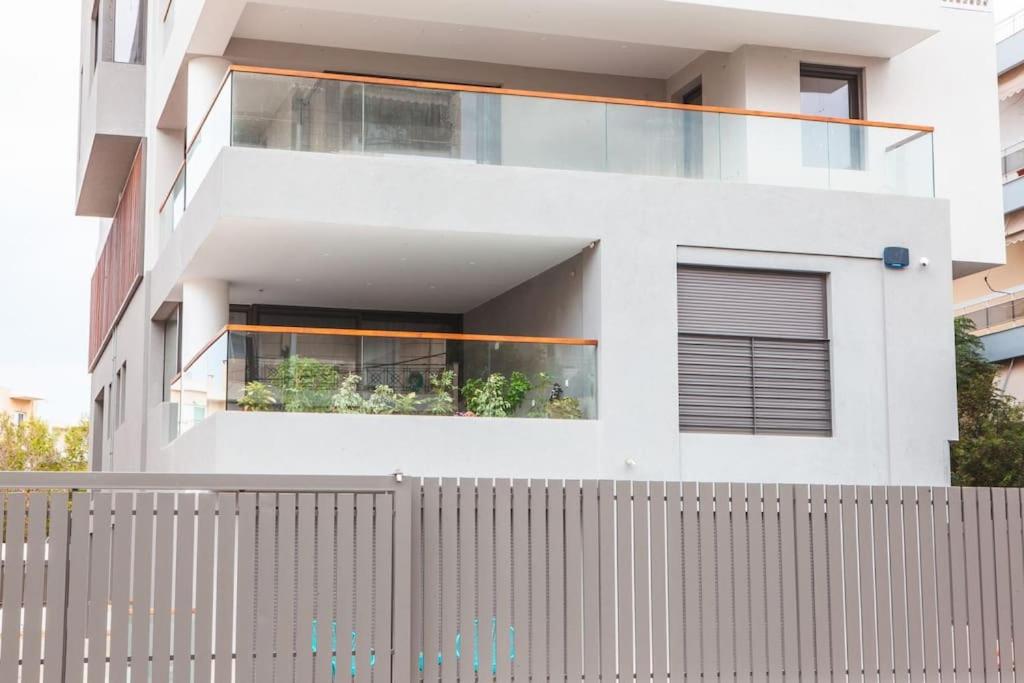 雅典Voula Luxury Apartment的前面有栅栏的白色房子