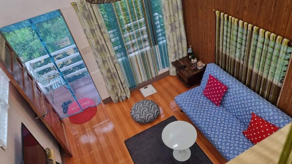 DaetCozy TinyHouse near SM City Daet的客厅配有蓝色沙发和红色枕头