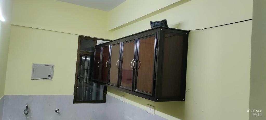 科钦1 BHK Flat in Kochi 904的墙上设有木橱柜的厨房