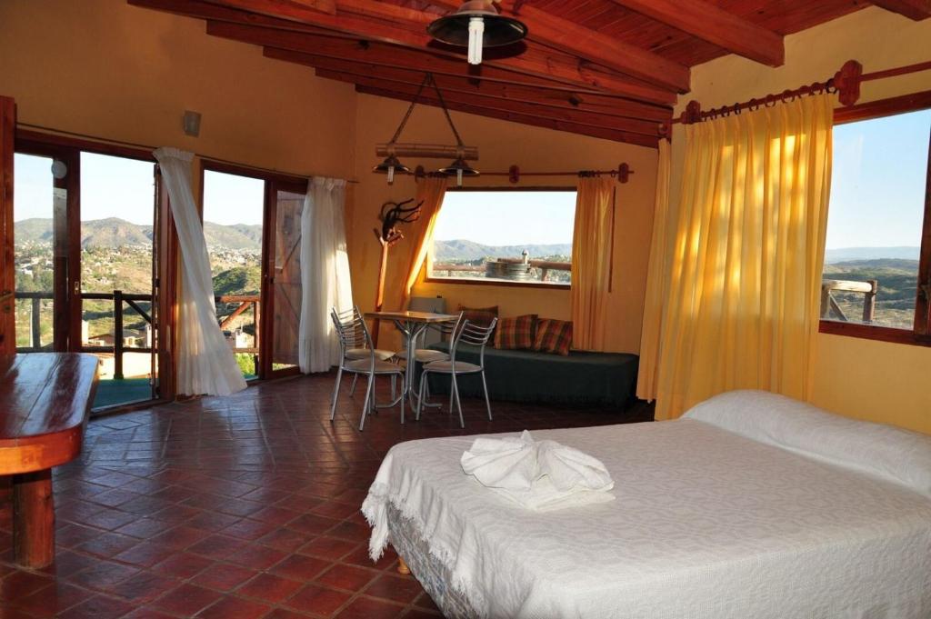维拉卡洛斯帕兹Cabañas Terrazas del Sol的卧室配有一张床和一张桌子及椅子