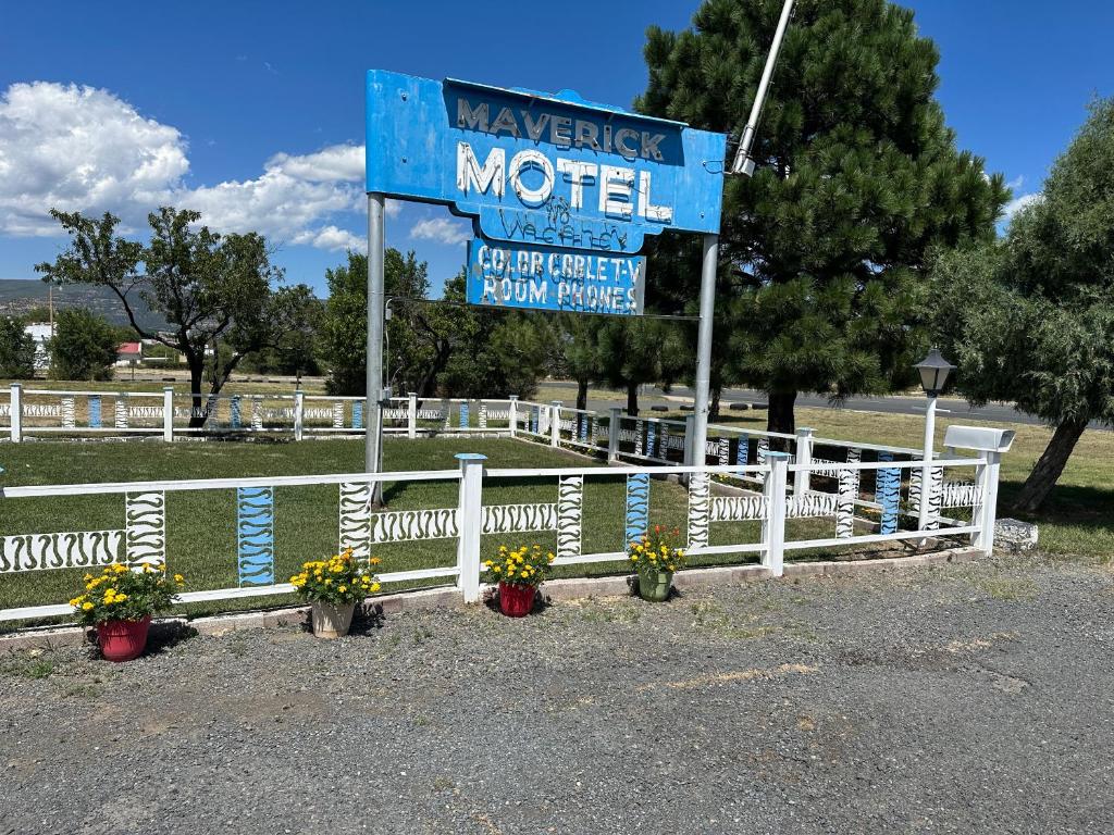 拉顿Maverick Motel的白色围栏旁的汽车旅馆标志