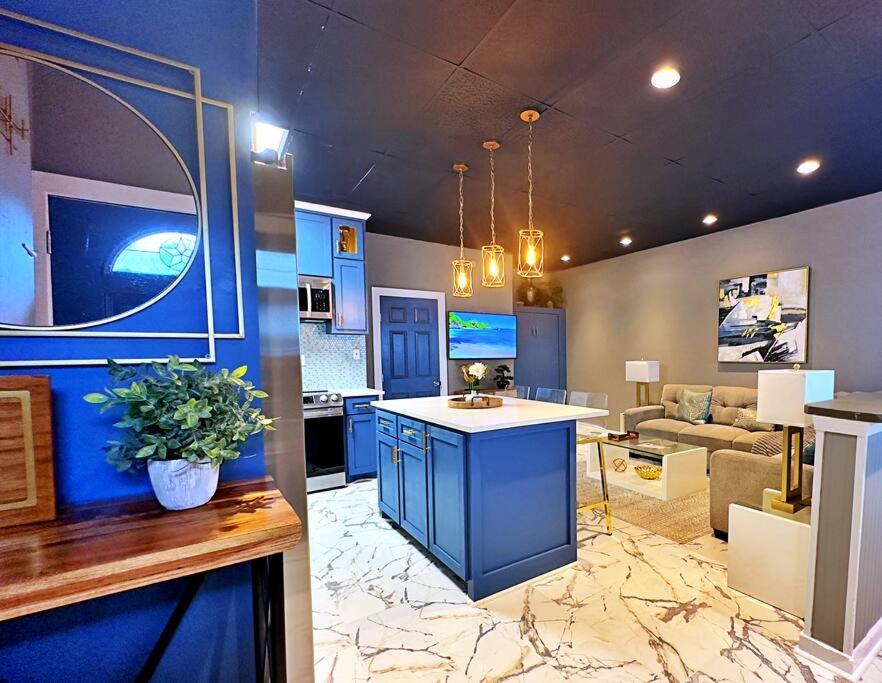 加尔维斯敦The Q Loft Galveston的一间设有蓝色橱柜的厨房和一间客厅
