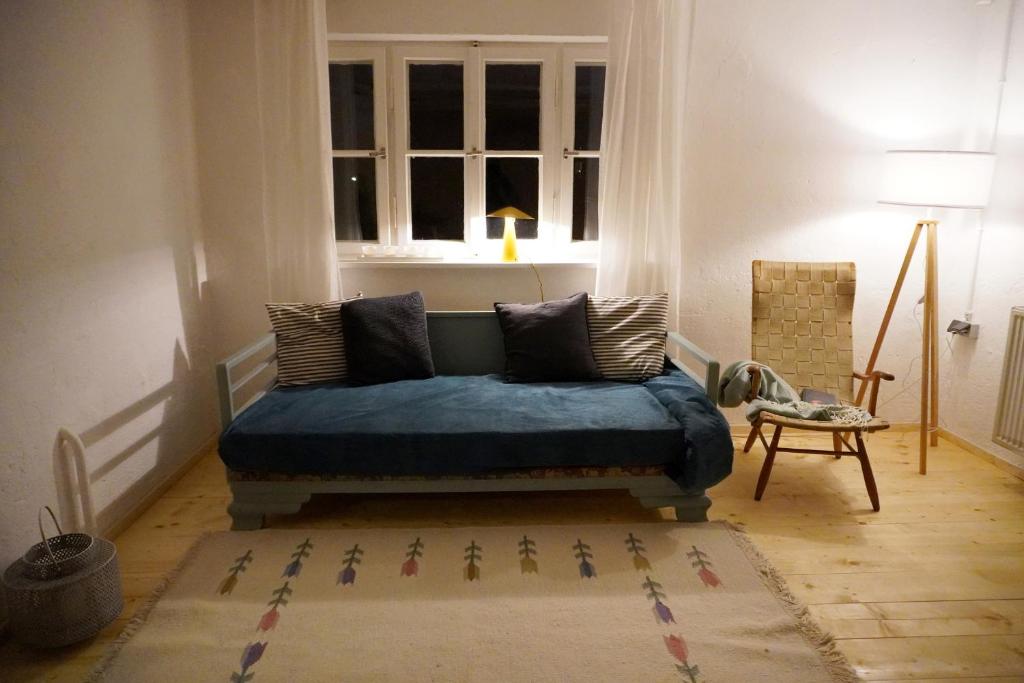 施泰因加登Oide Schreinerei的客厅,窗户前设有蓝色沙发