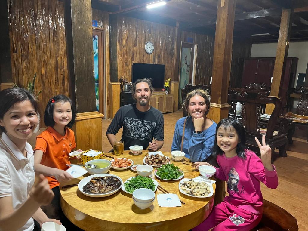 Mù Cang ChảiHomestay Hoà Thảo的一群人坐在桌子旁吃着食物