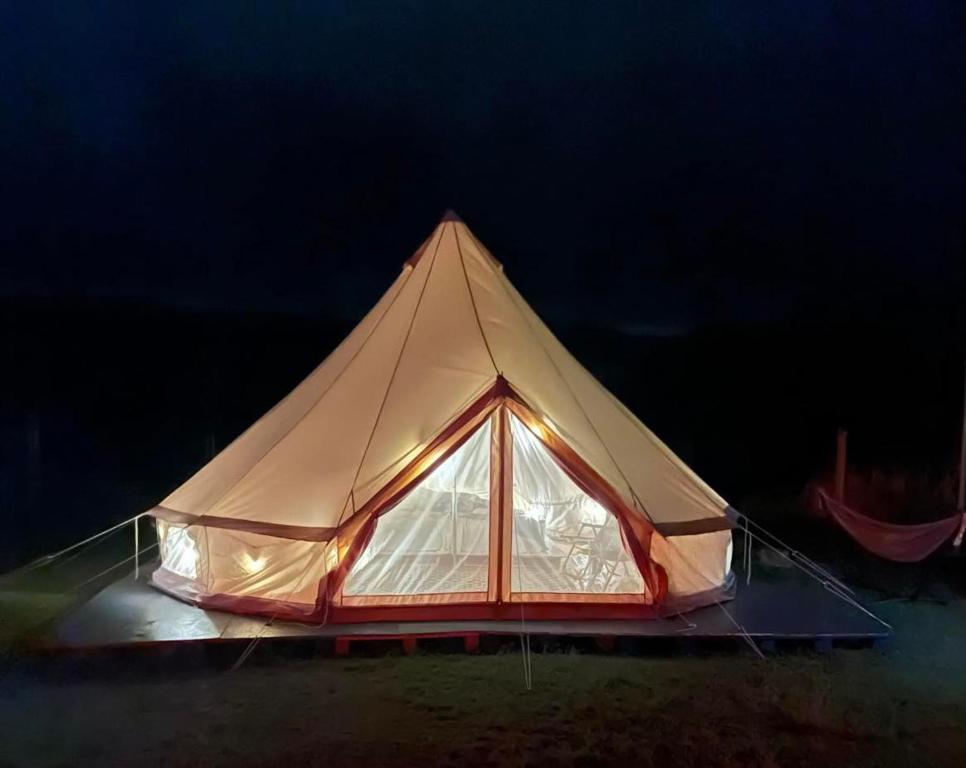 拉耶Maleka Farm: Tent Glamping North Shore Oahu的帐篷在黑暗中点燃