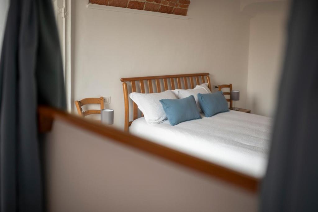 阿斯蒂Domus Antiche Mura的一间卧室配有一张带两个蓝色枕头的床
