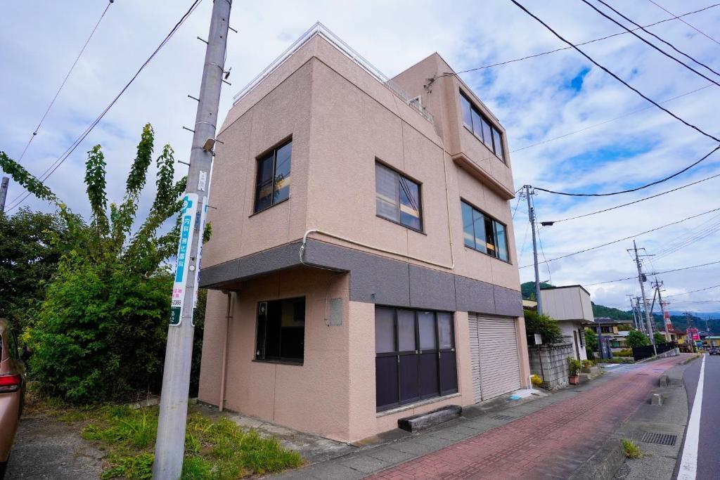 Tsuru Kotobuki-ke - Vacation STAY 15732的街道边的粉红色建筑
