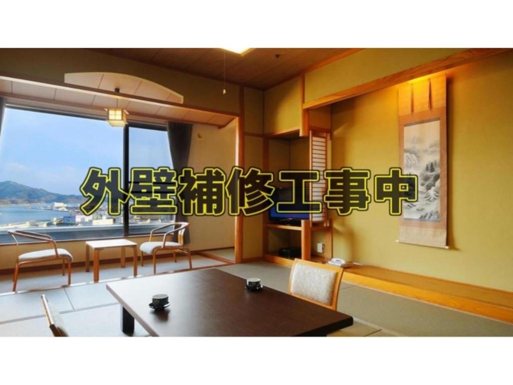 气仙沼市Sun Marine Kesennuma Hotel Kanyo - Vacation STAY 21044v的一间带桌椅和窗户的用餐室