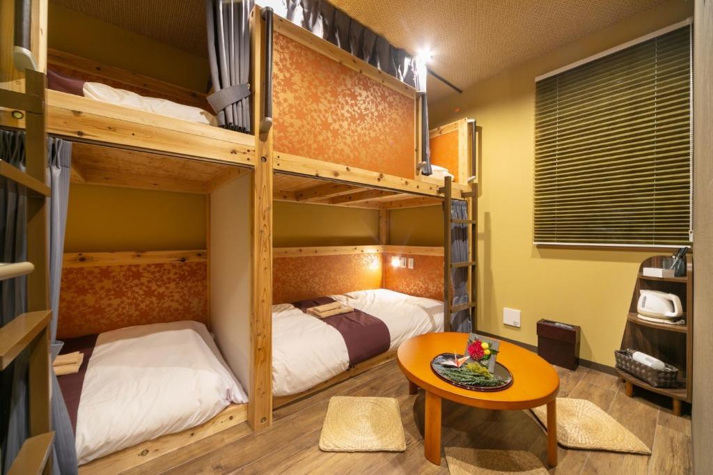东京IKIDANE Cozy Hotel Haneda Airport - Vacation STAY 25834v的客房设有两张双层床和一张桌子。
