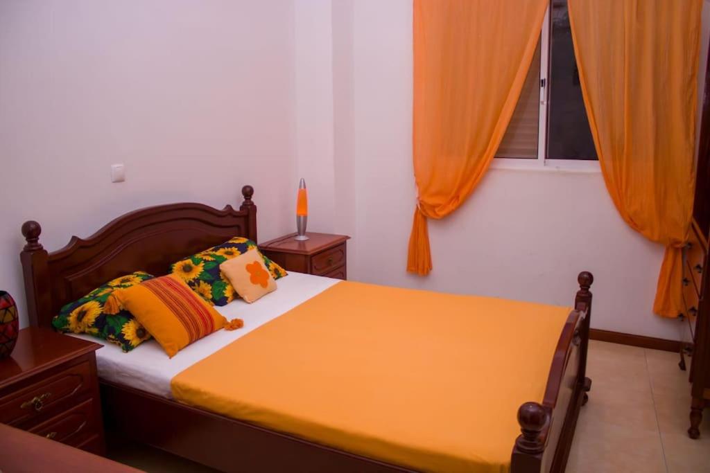 明德卢Casa Ramos Castro的一间卧室配有橙色窗帘的床