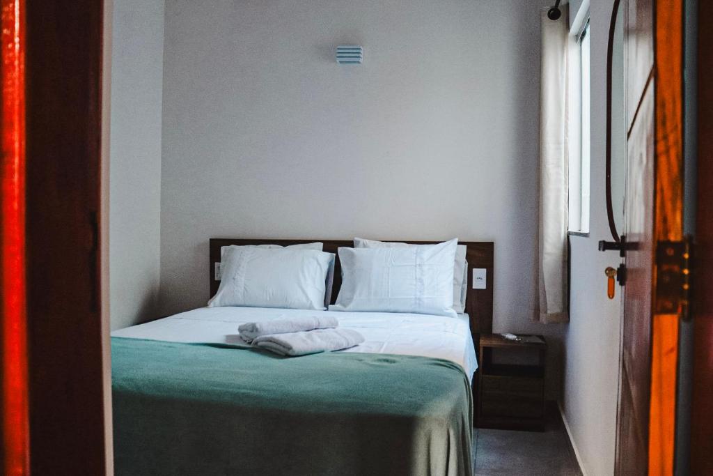 阿拉亚尔达茹达Residencial Ilha do Sol的一间卧室配有一张床,上面有两条毛巾
