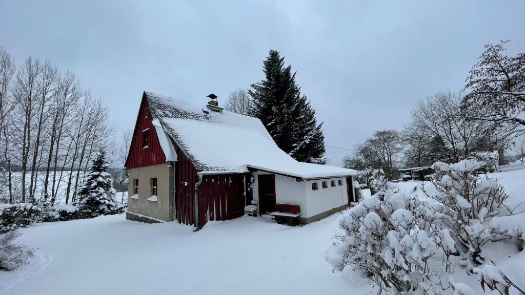 Lučany nad NisouChalupa Lučany的屋顶上白雪的红色谷仓
