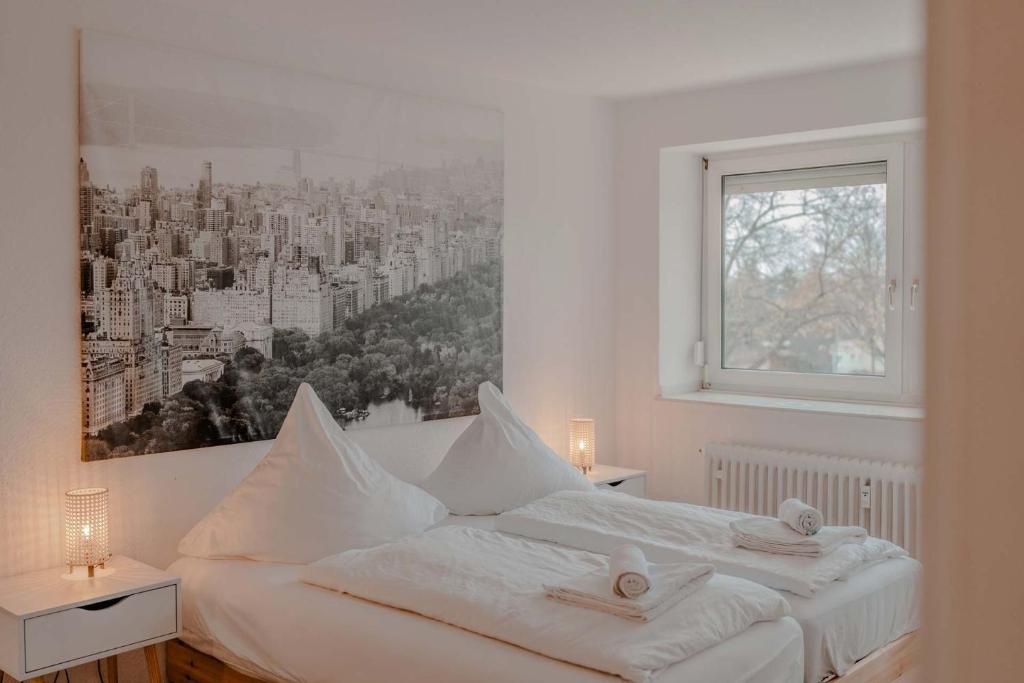 诺伊斯Apartment mit Küche, Arbeitsplatz und XXL Sofa的一间配备有白色床的卧室,享有城市美景