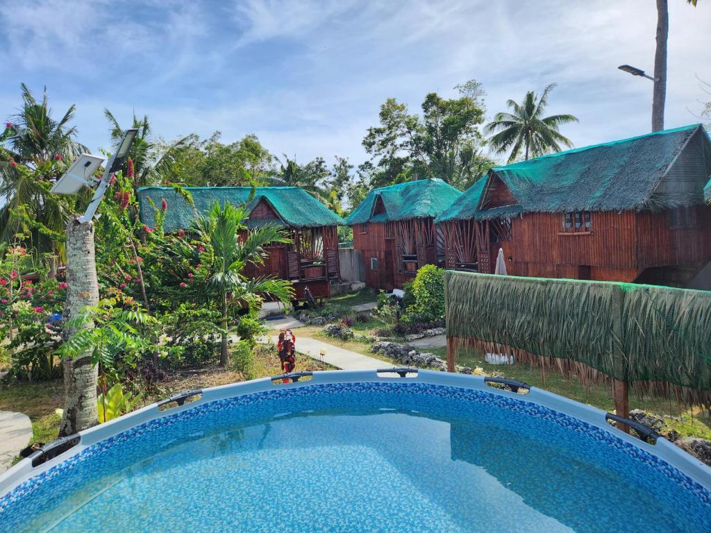 莫阿尔博阿Nirvana Bamboo & Dive resort的房屋前的游泳池